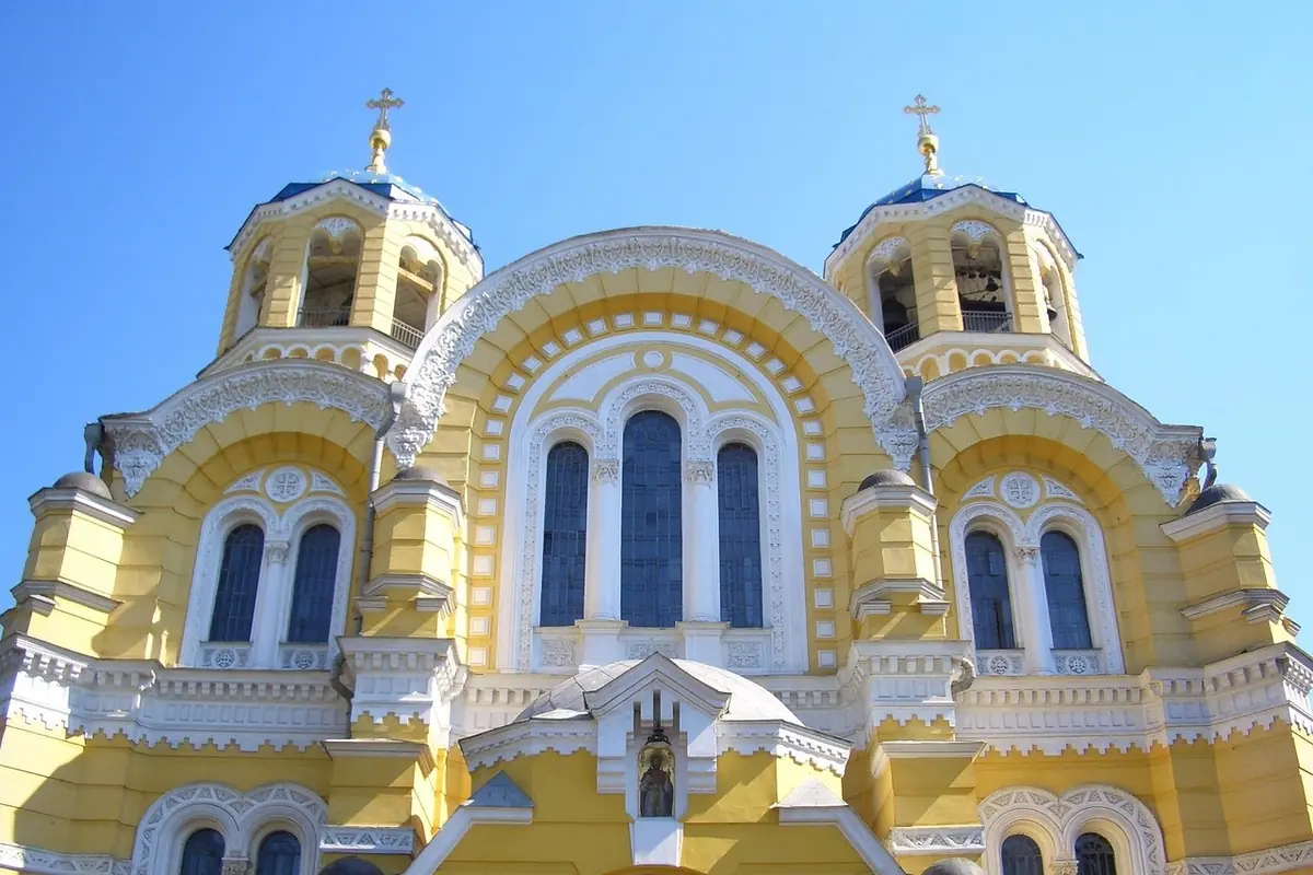 Жовтий фасад Володимирського собору в Києві з позолоченими хрестами на тлі неба
